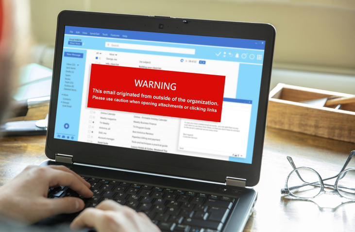 Red pop-up notification on a laptop warning about an external link in an email.