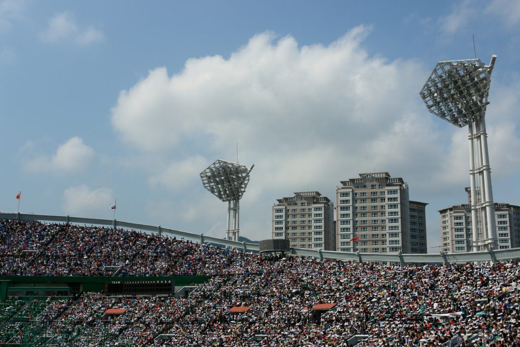 Full baseball stadium with fans cheering.